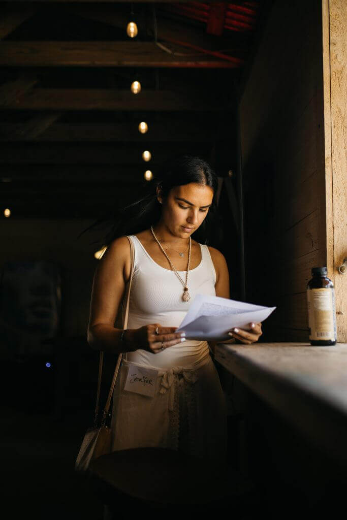 Woman reading on a dark stage at Artist Power Awakened