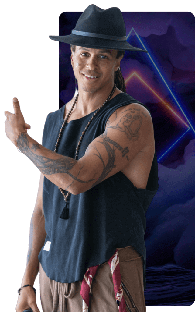 Man in a hat and vest gesturing on a stage backdrop